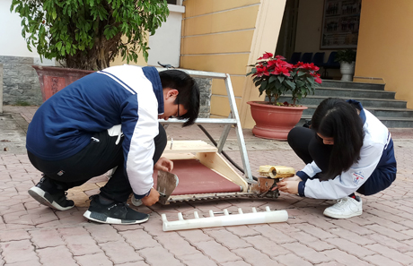 Em Đoàn Thị Thảo Linh và Nguyễn Đình Trung Đức cùng nghiên cứu hoàn thiện chiếc máy thu hoạch rau cầm tay.